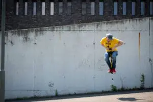 Photo qui montre un homme qui saute très haut avec son bâton sauteur (Pogo Stick)